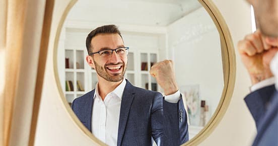 Man in the mirror shows a gesture of success