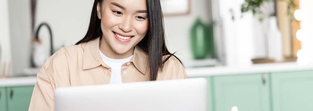 Reasons to learn programming online Smiling woman in front of computer