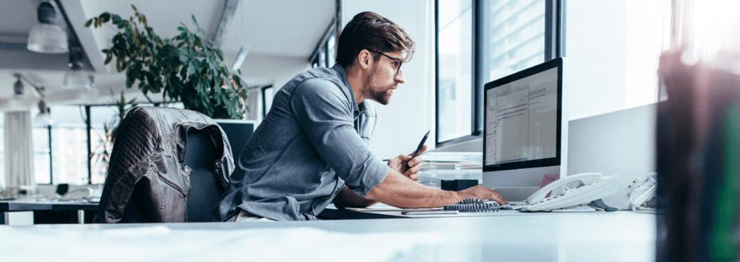 Coding school bootcamp franchise Man working in front of computer