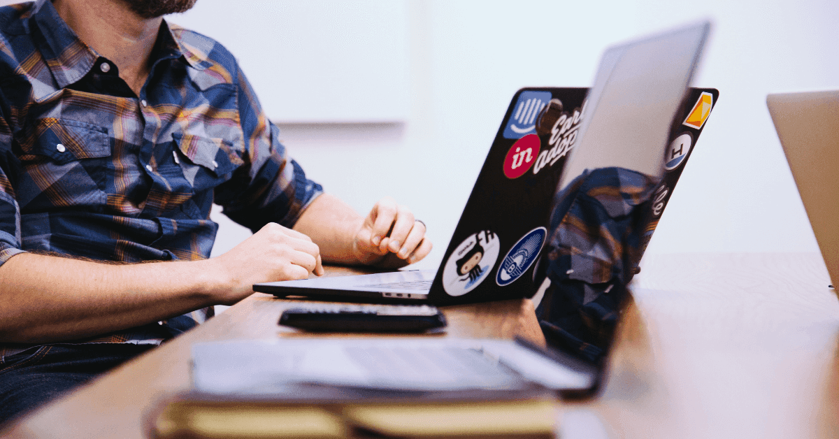 Computer science degree or bootcamp, which to choose Man with two laptops on the desk
