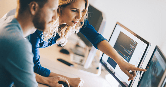 Coding teacher pointing at computer monitor